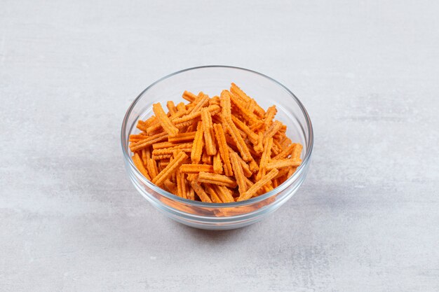 Fresh fries in glass bowl over white.