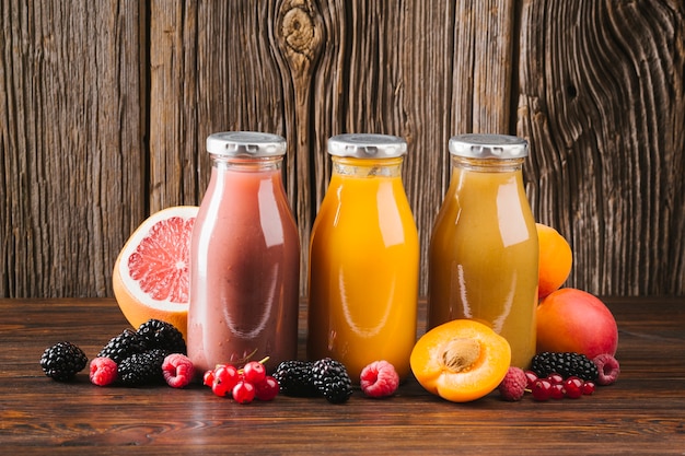 Fresh fruit smoothies on wooden background