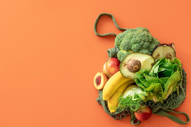 Fresh fruits and vegetables on a colored background flat lay