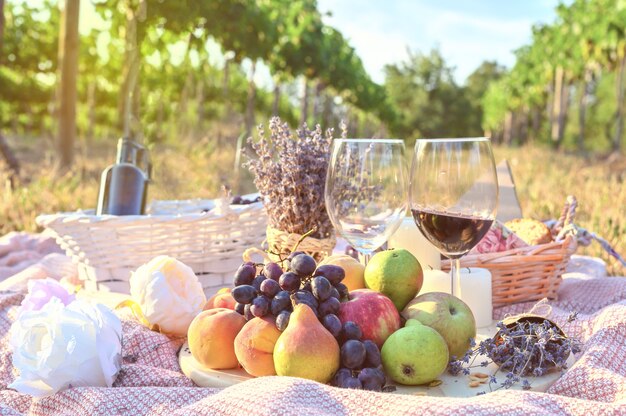 Пикник на открытом воздухе со свежими фруктами и бокалом вина