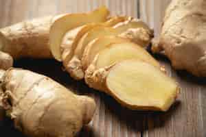 Free photo fresh ginger root and sliced on wooden table.