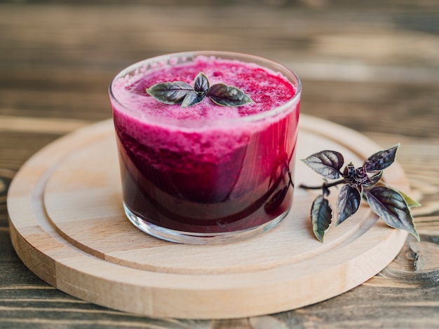 Fresh glass of beetroot juice on wooden tray