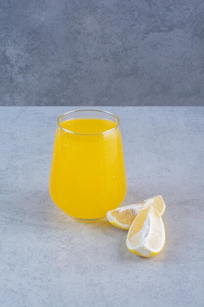 Fresh glass of lemonade with sliced lemon on gray surface