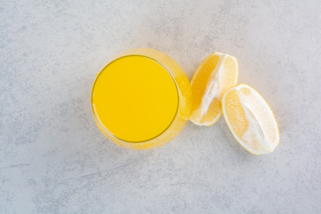 Fresh glass of lemonade with sliced lemon on gray.