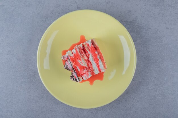 Свежий грейпфрутовый торт с соусом на желтой тарелке