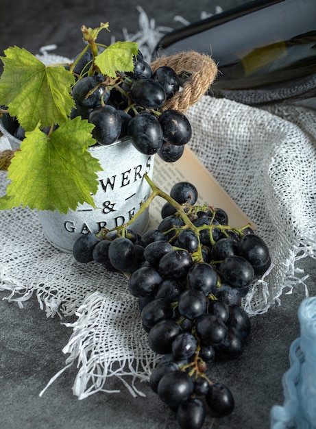 Fresh grapes with leaves in bucket on sackcloth 