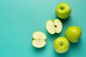 Fresh green apples cut in half put on light green background