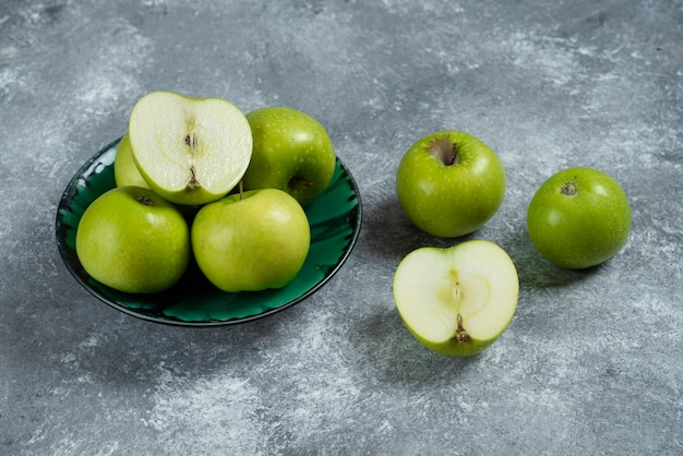 Free photo fresh green apples in green bowl.