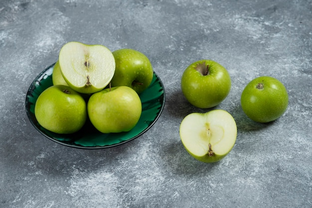 Fresh green apples in green bowl.