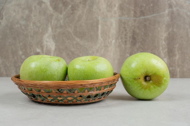 Fresh green apples in wooden basket. 