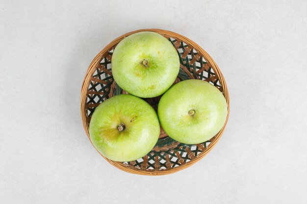 Fresh green apples in wooden basket