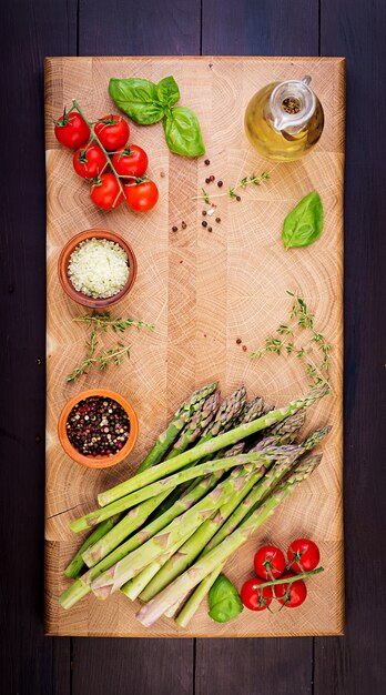 Fresh green asparagus on a rustic wooden table with copy space. Top view