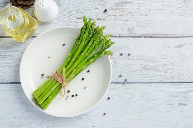 Free photo fresh green asparagus on wooden background