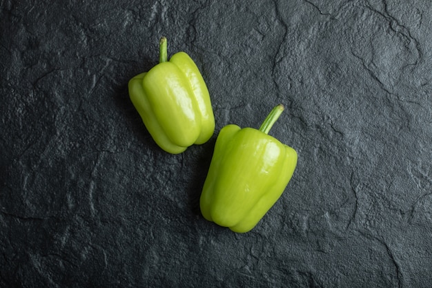 Fresh green bell peppers on black.