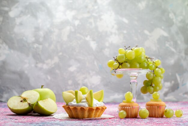 fresh green grapes whole sour and delicious fruits with little cakes on light