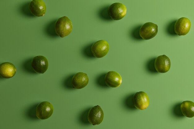 Свежие зеленые здоровые лаймы на яркой поверхности. Цитрусовые используются для придания аромата пище, украшения или топпинга. Потребление растительных продуктов, богатых витаминами и минералами, для хорошего здоровья или диеты