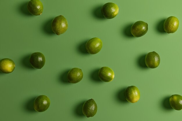 Fresh green healthy limes on bright surface. Citrus fruit used to accent flavors in foods, garnish or topping. Consumption of plant products rich in vitamins and minerals for good health or diet