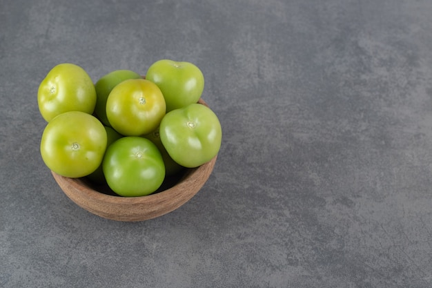 무료 사진 나무 그릇에 신선한 녹색 토마토입니다. 고품질 사진
