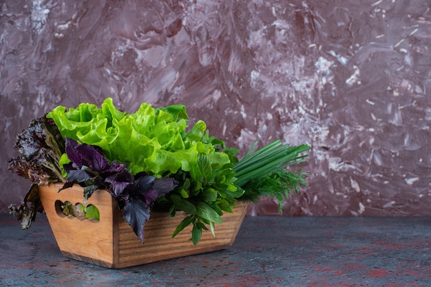 Fresh greens in a box, on the marble background. 