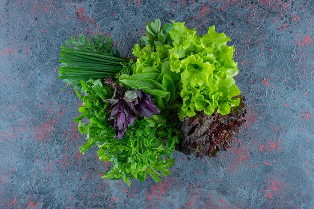 Fresh greens in a wooden box, on the marble background. 