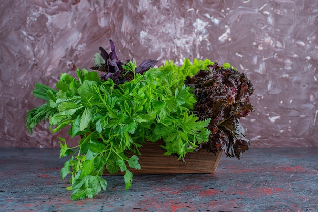 Fresh greens in a wooden box on the marble surface