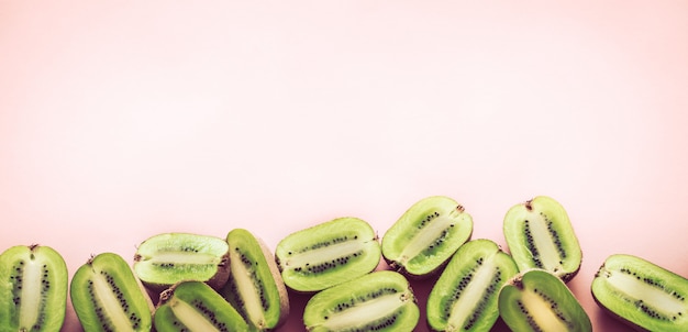 Free photo fresh halves of kiwi on a pink background