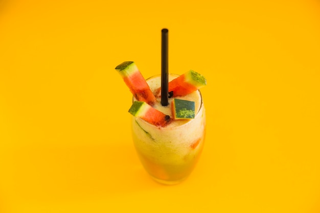 Свежий здоровый коктейль с ломтиком арбуза на желтом фоне