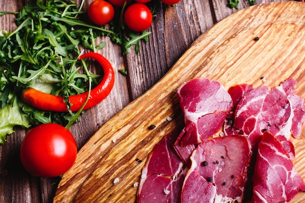 신선하고 건강한 음식. 얇게 썬된 붉은 고기 arugula와 나무 테이블에 놓여