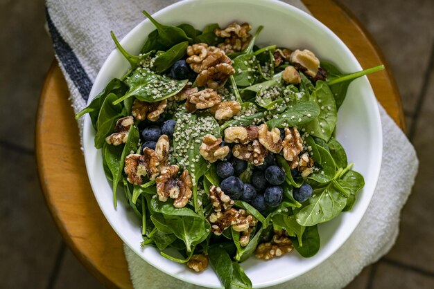 Above fresh healthy moist green spinach, blueberry, walnut and h