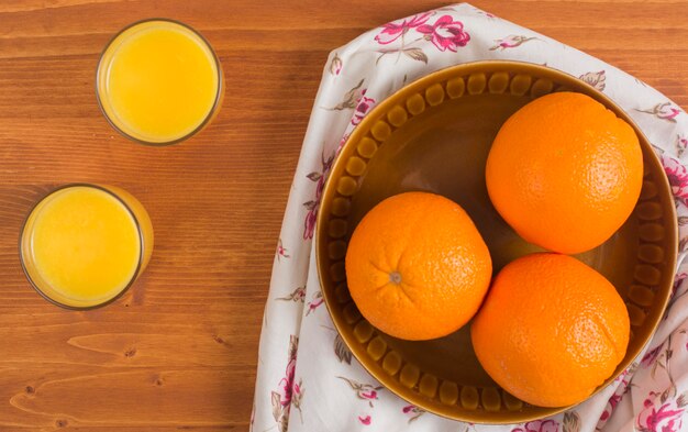 Fresh healthy oranges juice in the glasses on wooden table