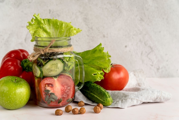 Fresh healthy vegetable slice in mason jar with fruits and hazelnut