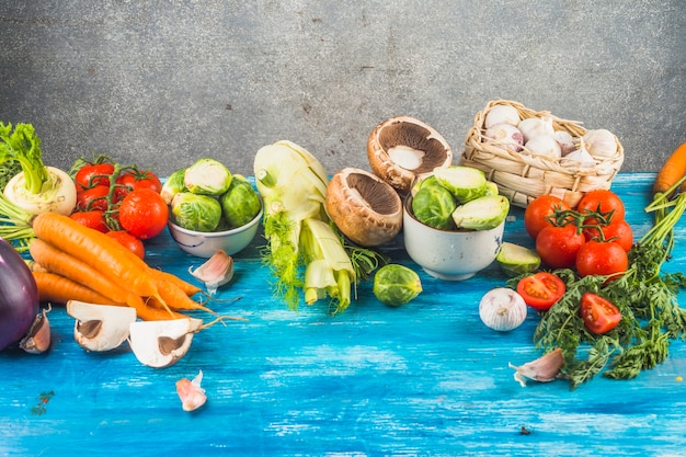 Fresh healthy vegetables on blue wooden tabletop