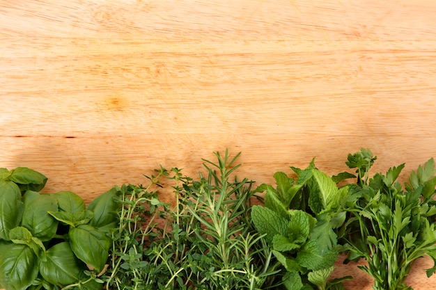 Foto gratuita erbe fresche sulla tavola di legno