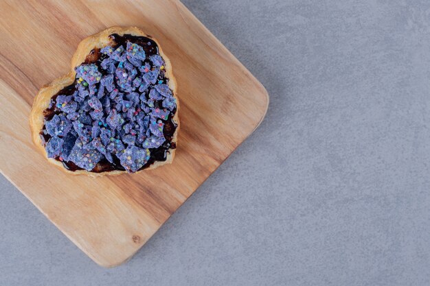 Fresh homemade blueberry cookie on blue wooden plate over grey surface