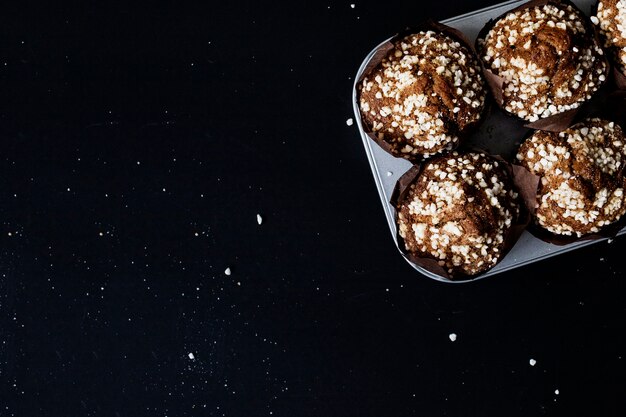 Fresh homemade chocolate muffin cake on black backdrop