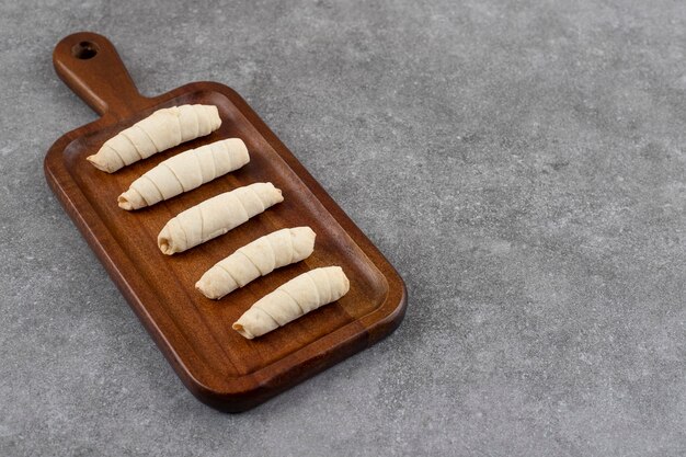 Fresh homemade cookies in a row over wooden cutting board