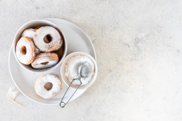 흰색 배경에 가루 설탕으로 덮인 신선한 홈메이드 튀긴 도넛 선택적 초점