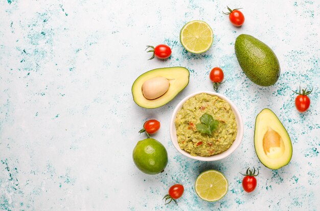 Fresh homemade hot guacamole sauce with ingredients, top view