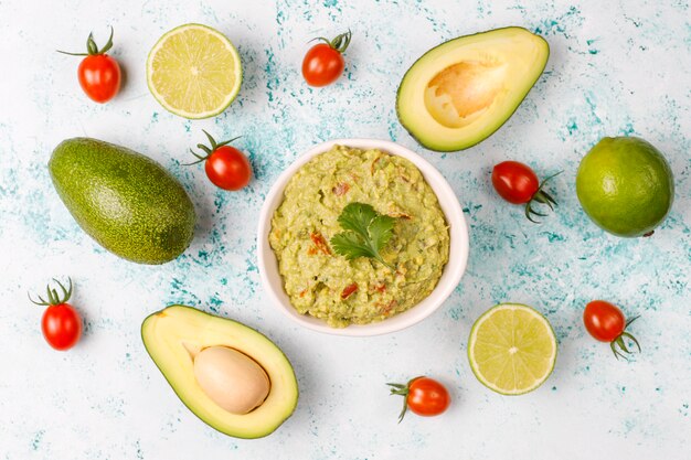 Fresh homemade hot guacamole sauce with ingredients, top view