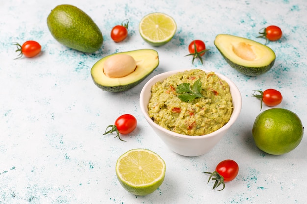 Fresh homemade hot guacamole sauce with ingredients, top view