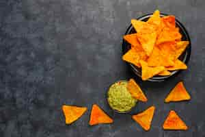 Free photo fresh homemade hot guacamole sauce with nachos, top view