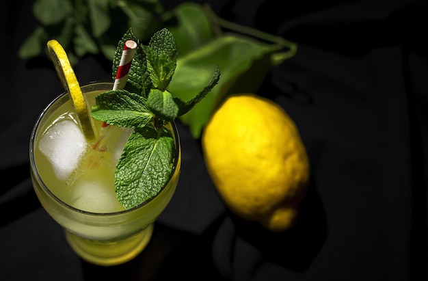 Свежий домашний коктейль из лимонада или мохито с лимонной мятой и льдом на темном фоне Premium Фотографии