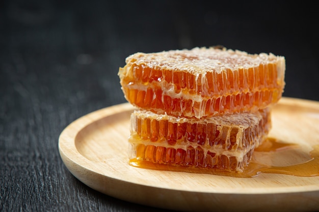 Fresh honeycombs on dark wooden surface