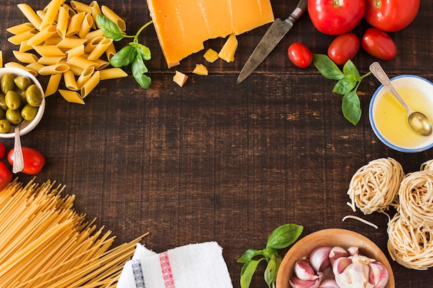 Fresh ingredients for cooking pasta on wooden background