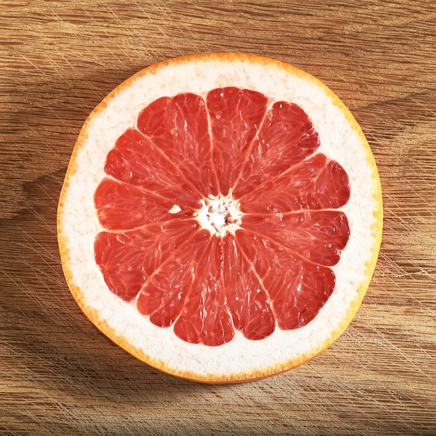 Free photo fresh juicy grapefruit slices on wooden