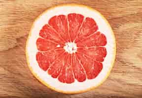 Free photo fresh juicy grapefruit slices on wooden