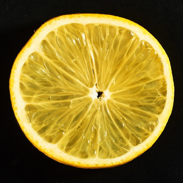 Fresh juicy slices of lemon on a black.