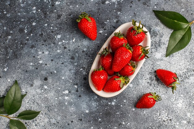 Fresh juicy strawberries on light wall,top view