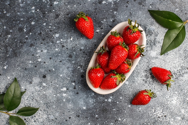 Fresh juicy strawberries on light wall,top view