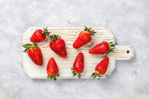 Fresh juicy strawberries on light wall,top view